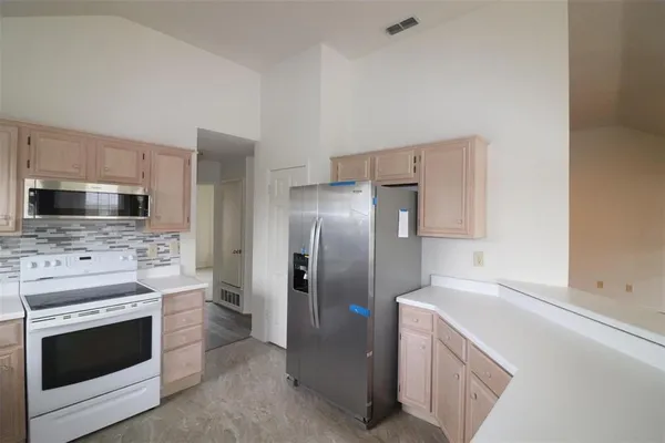 a kitchen with stainless steel appliances a stove a microwave and a refrigerator