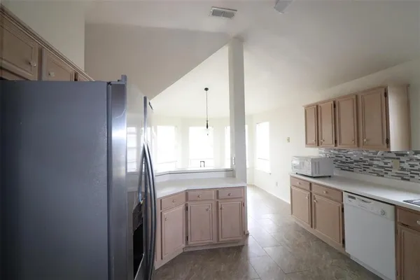 a kitchen with stainless steel appliances granite countertop a refrigerator and a sink