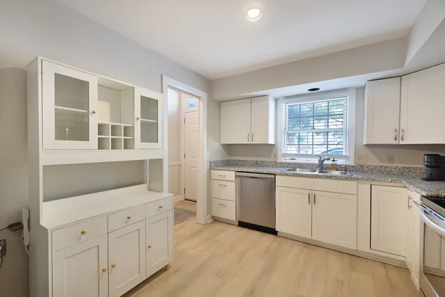 a kitchen with granite countertop white cabinets and white appliances