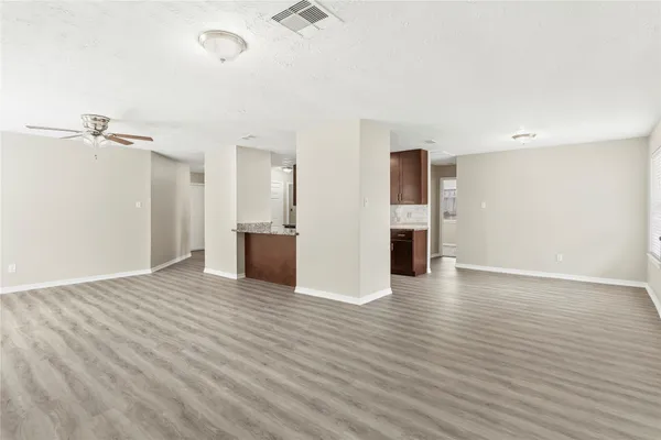 a view of a kitchen with a fridge and wooden floor
