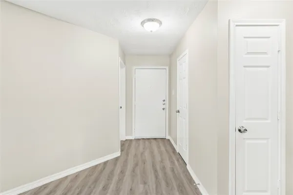 a view of a hallway with wooden floor