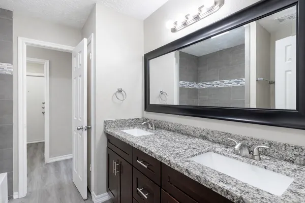 a bathroom with a granite countertop sink and a mirror
