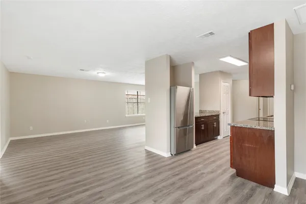 a view of kitchen with refrigerator stove and wooden cabinets