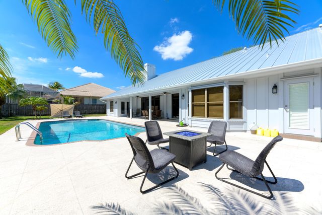 a view of a house with swimming pool and sitting area