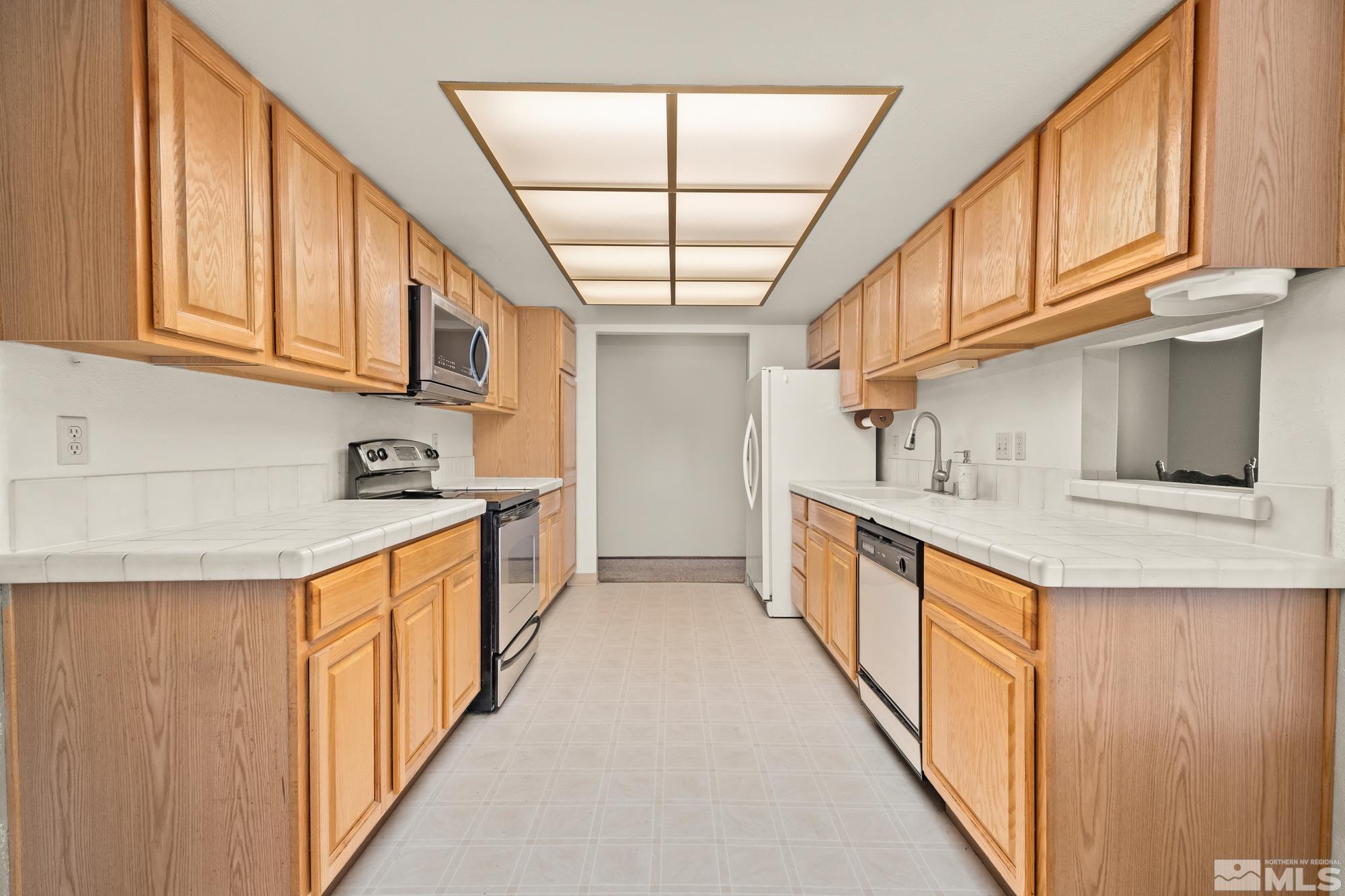 560 Peter Reno, NV 89503 - Photo 7 of 21 a kitchen with stainless steel appliances granite countertop a sink and dishwasher a refrigerator with wooden cabinets
