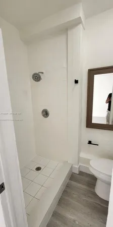 a bathroom with a granite countertop sink a toilet and shower