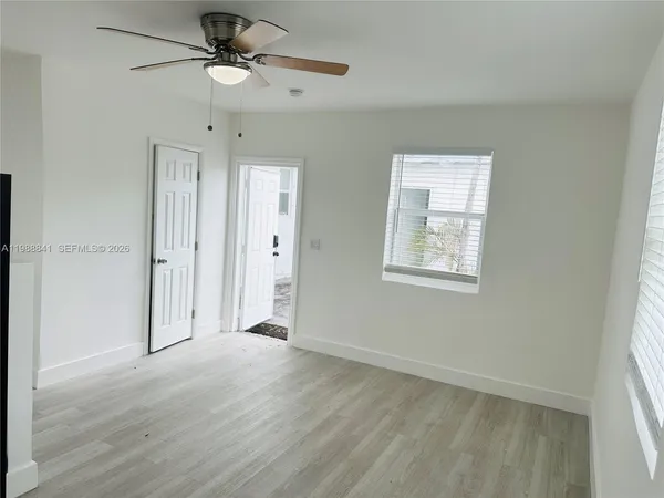 an empty room with fan and windows