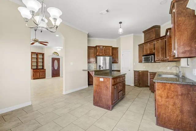 a large kitchen with stainless steel appliances granite countertop a stove a sink a microwave and dining table