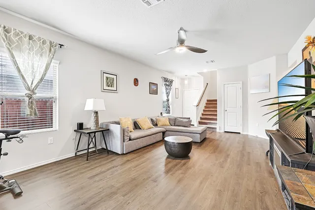 a living room with furniture and a wooden floor
