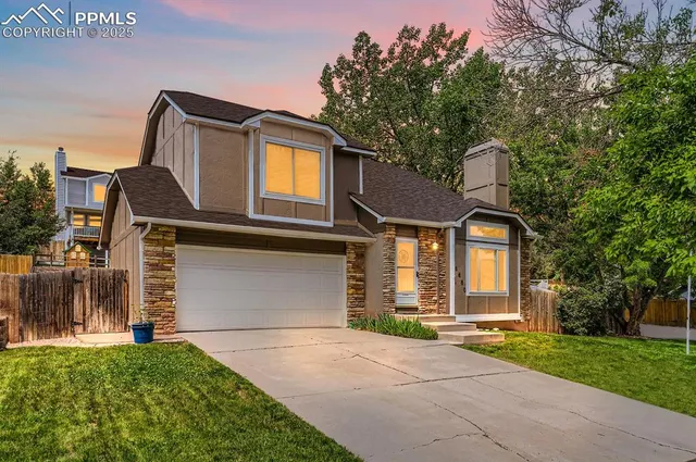 a front view of a house with a garden and garage