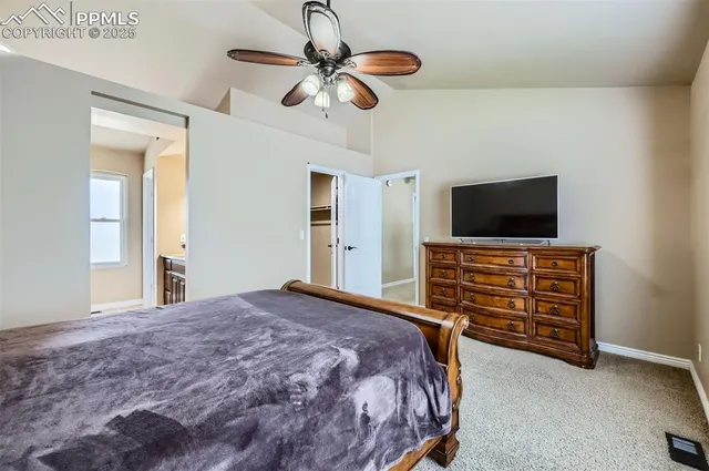 a bedroom with a bed and a flat tv screen on dresser