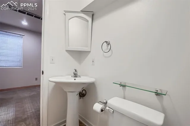 a bathroom with a sink mirror vanity and toilet