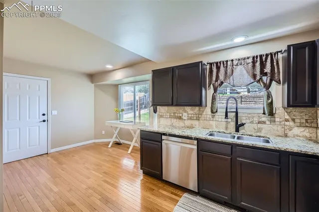 a kitchen with a sink cabinets and wooden floor