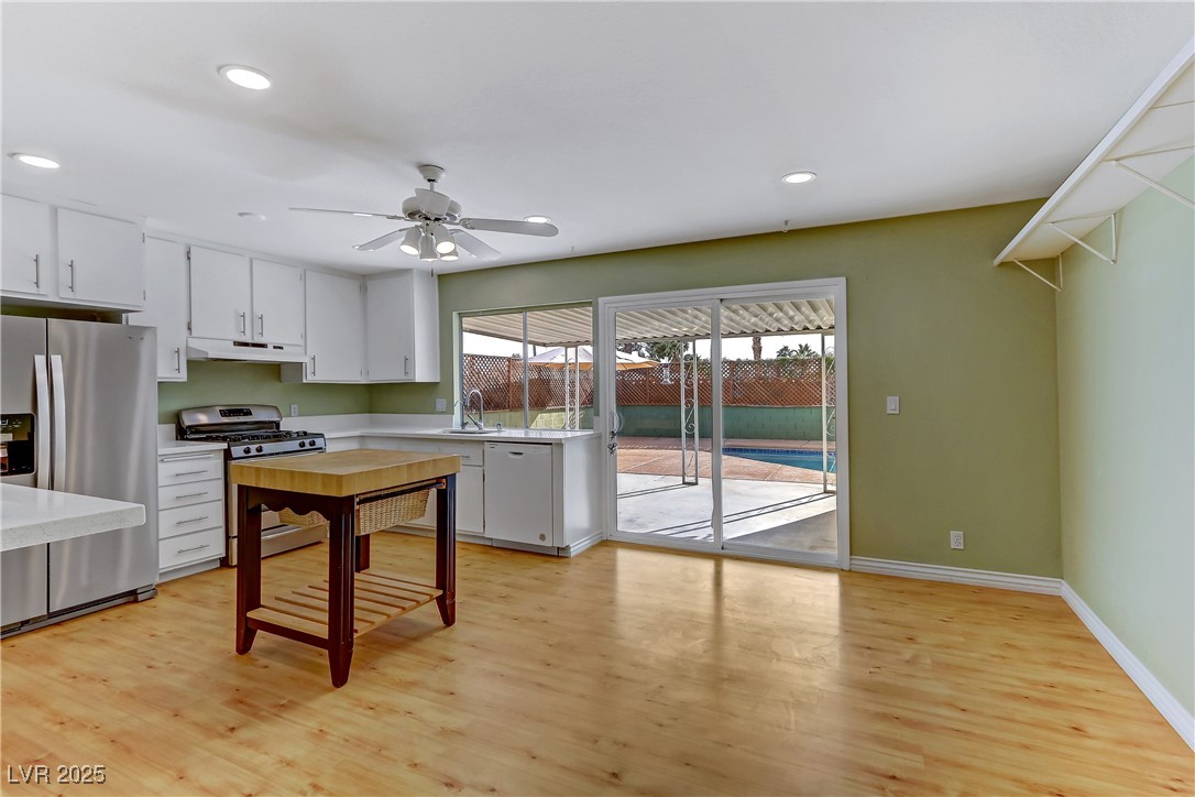 7301 Pleasant View Avenue Las Vegas, NV 89147 - Photo 11 of 37 Kitchen featuring appliances with stainless steel finishes, white cabinets, light wood-style flooring, recessed lighting, and a ceiling fan