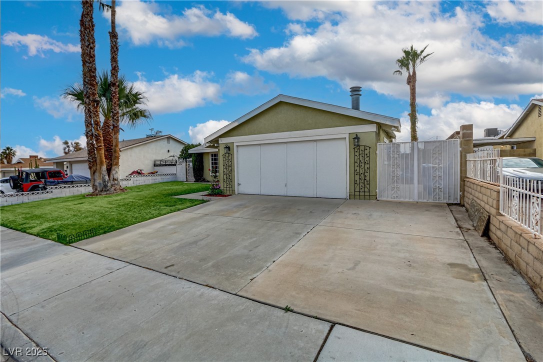 7301 Pleasant View Avenue Las Vegas, NV 89147 - Photo 2 of 37 Ranch-style house featuring stucco siding, concrete driveway, a garage, and a gate