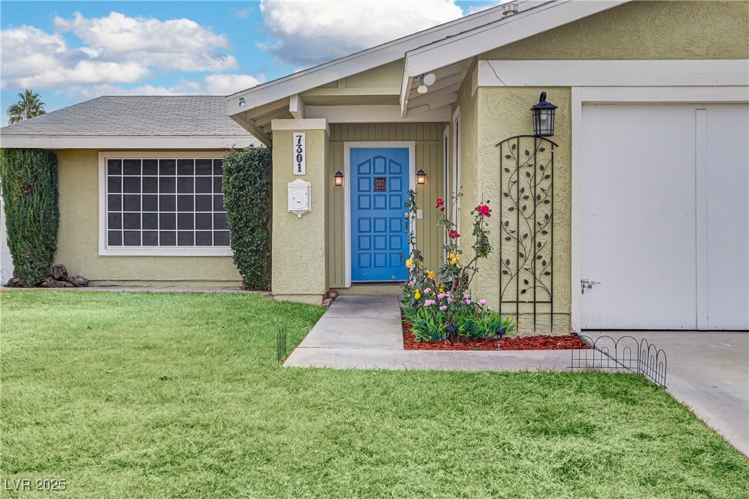 7301 Pleasant View Avenue Las Vegas, NV 89147 - Photo 5 of 37 View of exterior entry with stucco siding and a yard