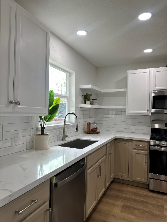 726 Banton Street Channelview, TX 77530 - Photo 6 of 30 a kitchen with a sink dishwasher a stove and cabinets