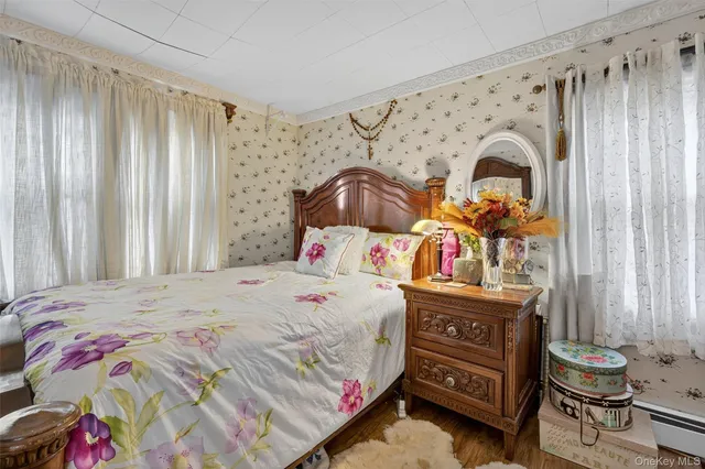 a bedroom with a bed a dresser and a window