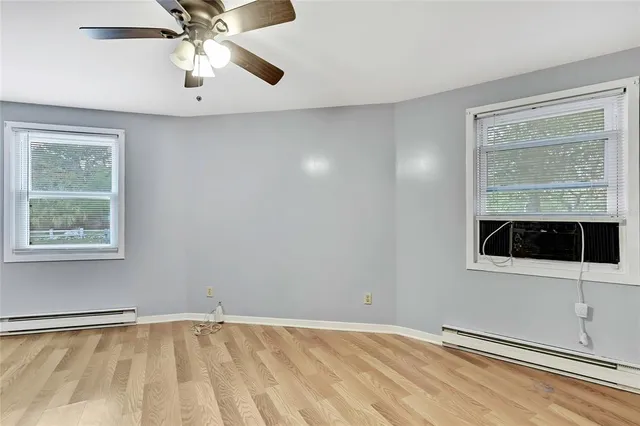 an empty room with a window and a ceiling fan