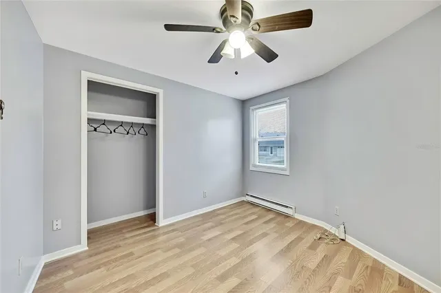 an empty room with a window and a ceiling fan