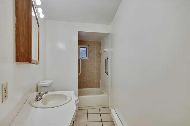 a bathroom with a granite countertop sink a toilet and shower