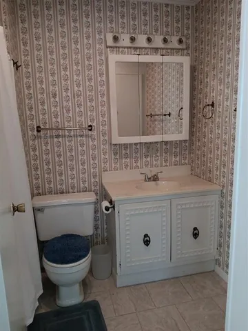 a view of an empty room with a window and a chandelier fan