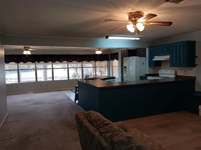 a kitchen with stainless steel appliances granite countertop a table chairs sink and cabinets