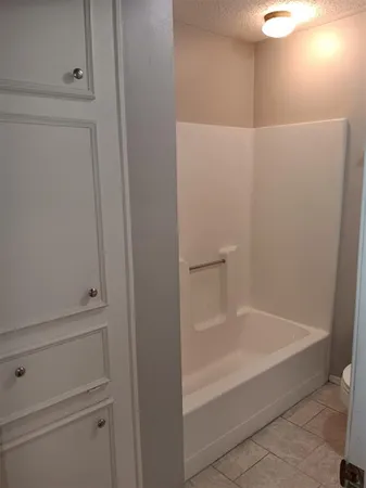 a bathroom with a granite countertop toilet and a sink