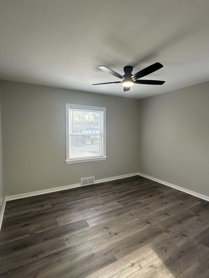 513 Cookane Avenue Elgin, IL 60120 - Photo 13 of 26 an empty room with wooden floor ceiling fan and windows