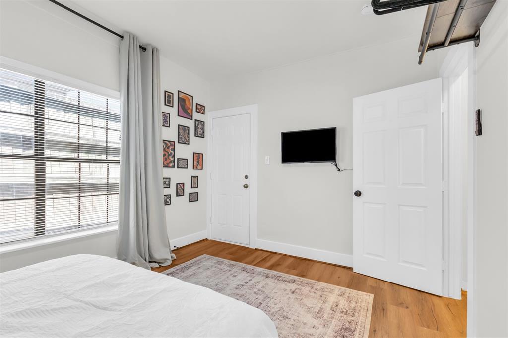 4121 Junius Street, Unit 4123 Dallas, TX 75246 - Photo 22 of 23 a bedroom with a bed and a flat screen tv