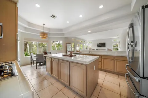 a kitchen with kitchen island granite countertop a sink counter top space appliances and cabinets