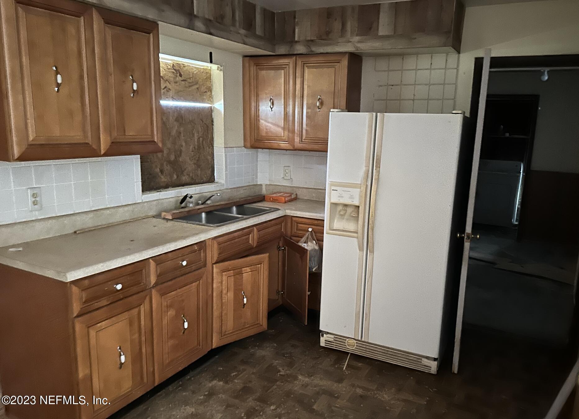 7472 Melvin Road Jacksonville, FL 32210 - Photo 4 of 5 a kitchen with a sink a refrigerator and cabinets