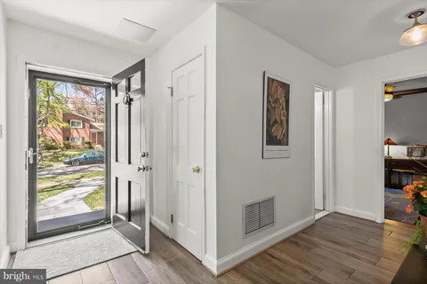 a view of a hallway with wooden floor and closet