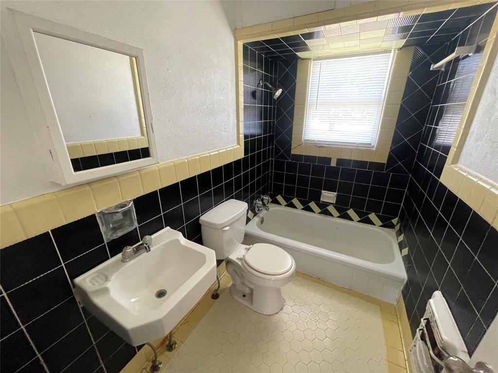2011 Gilbert Avenue Wichita Falls, TX 76301 - Photo 4 of 7 a bathroom with a toilet a sink a window and mirror