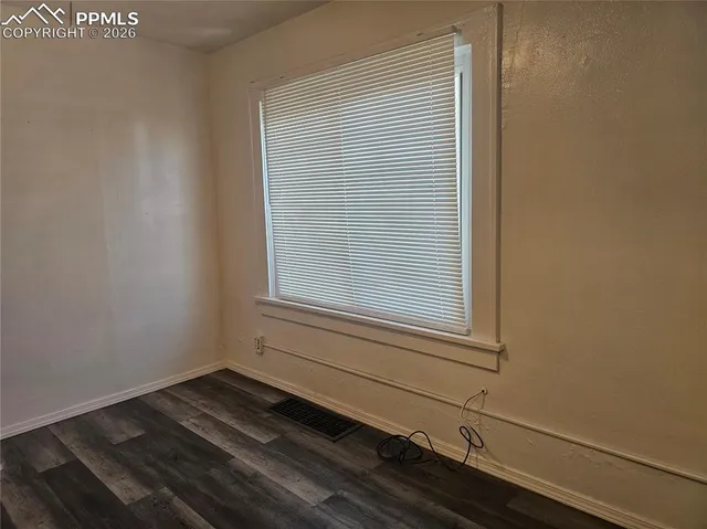 a view of a room that has a window and wooden floor