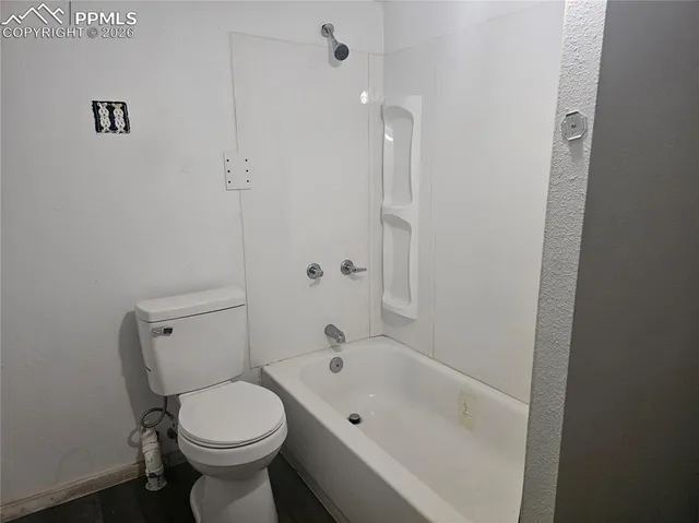 a bathroom with a bathtub shower sink vanity and toilet
