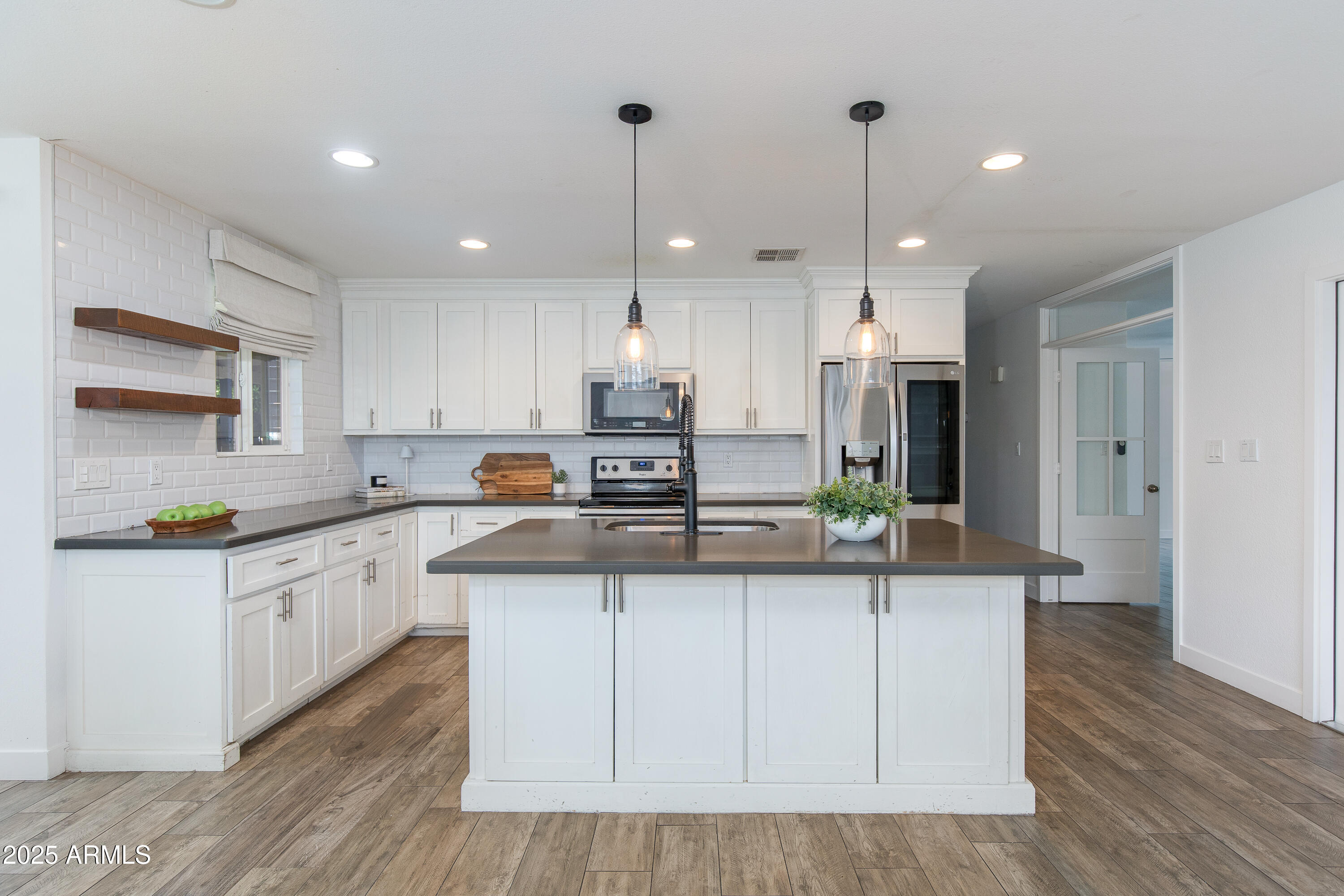 a kitchen with kitchen island granite countertop a sink a counter space appliances and cabinets