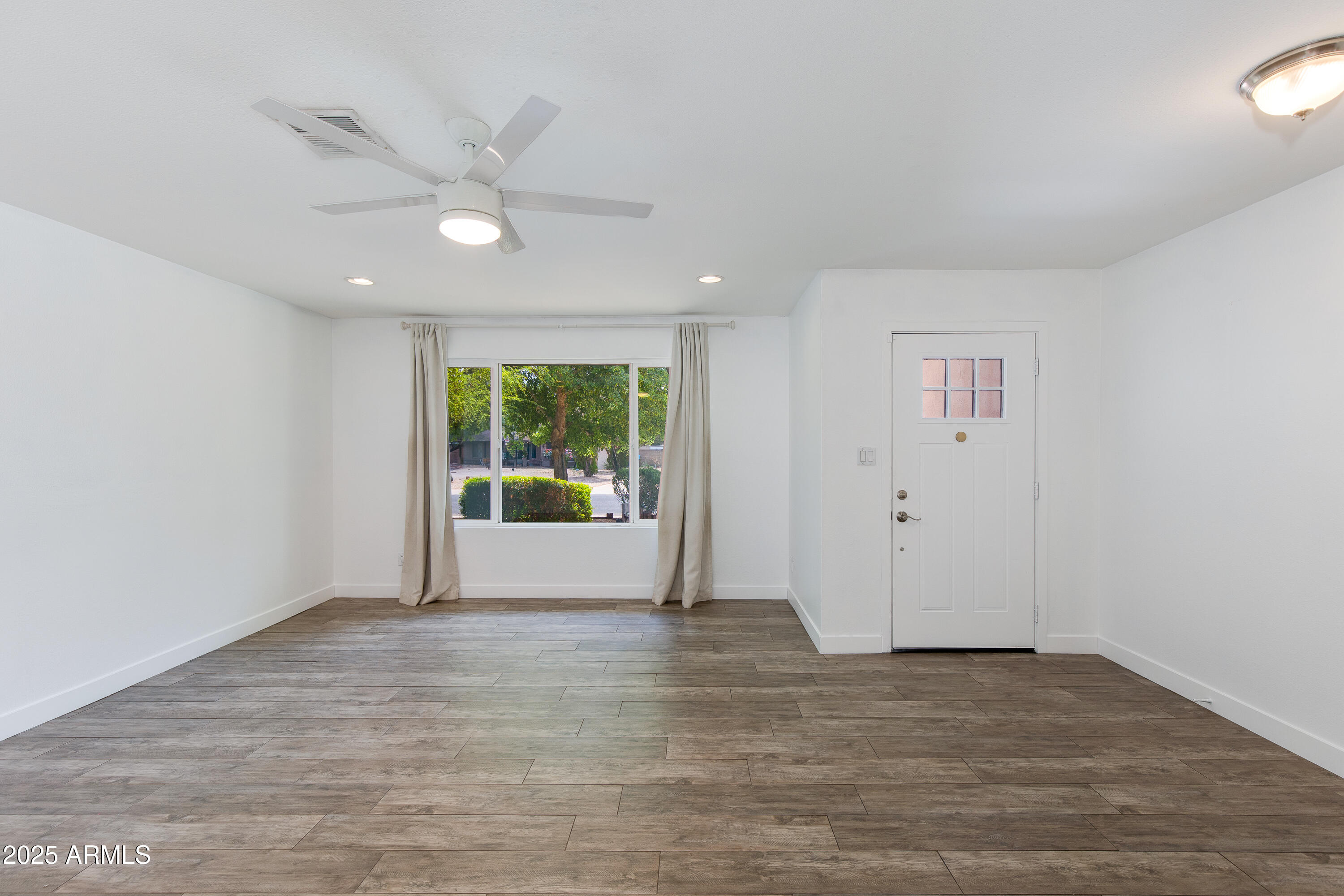1820 West Seldon Way Phoenix, AZ 85021 - Photo 4 of 29 a view of an empty room with wooden floor and a window