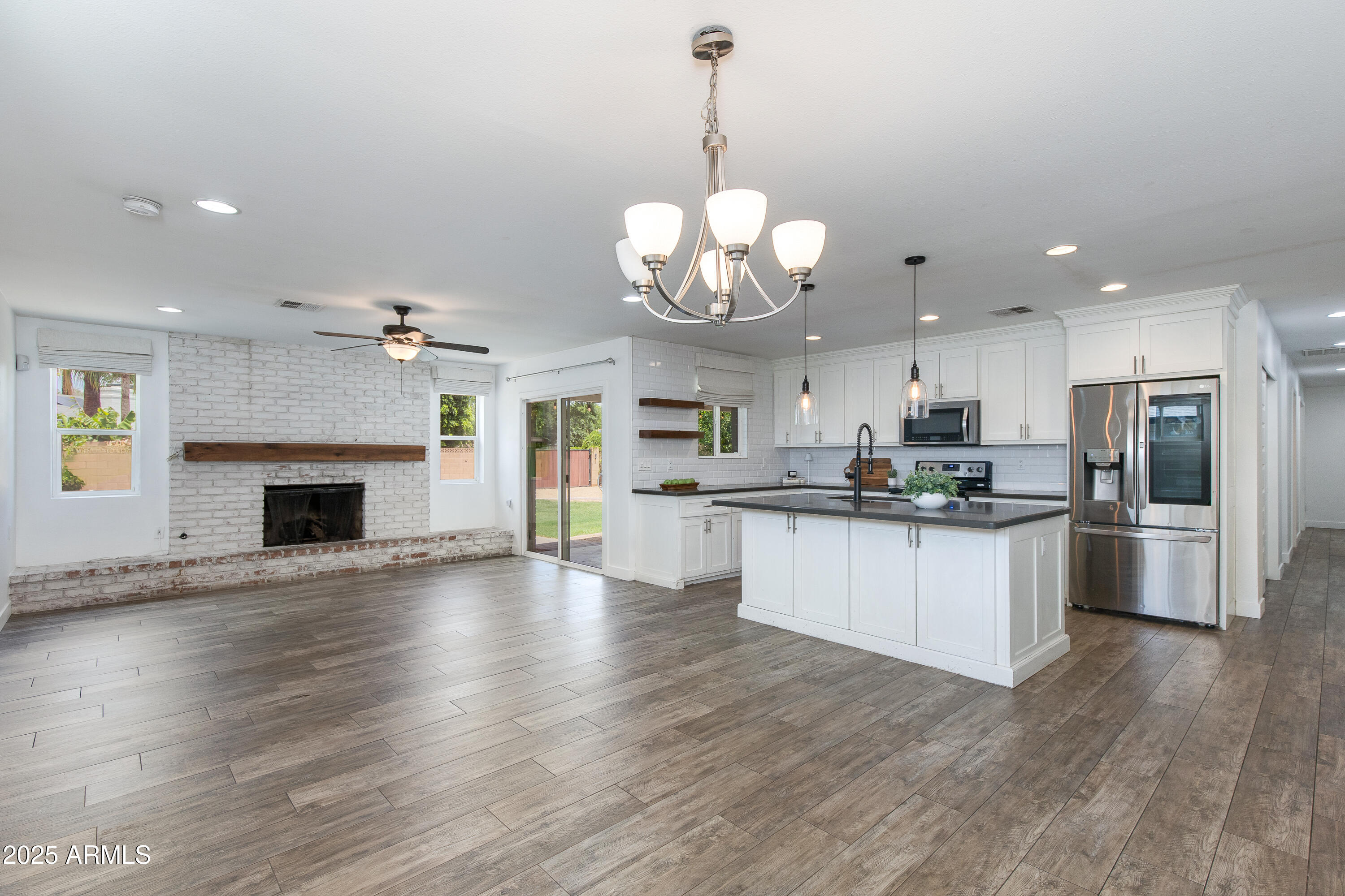 1820 West Seldon Way Phoenix, AZ 85021 - Photo 7 of 29 a large kitchen with granite countertop stainless steel appliances a large counter top a fireplace and cabinets