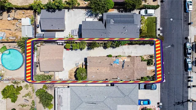 an aerial view of residential houses with outdoor space and parking