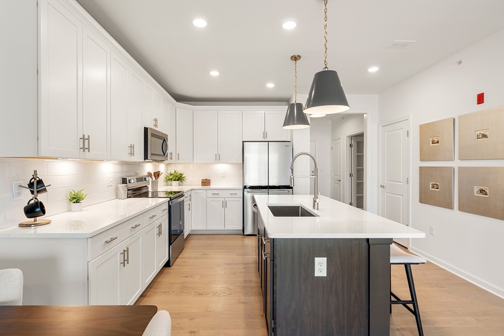 1 Codman Way, Unit 403 Westborough, MA 01581 - Photo 6 of 35 a kitchen that has a lot of white cabinets and stainless steel appliances