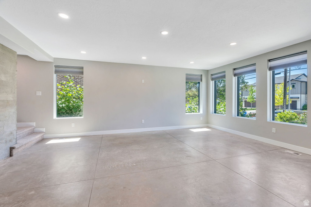 7045 South 300 East Midvale, UT 84047 - Photo 12 of 49 Spacious room featuring light gray walls, an exposed concrete structural element, and recessed ceiling lighting
