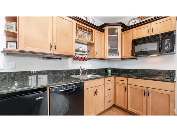a living room with stainless steel appliances kitchen island granite countertop furniture and a flat screen tv