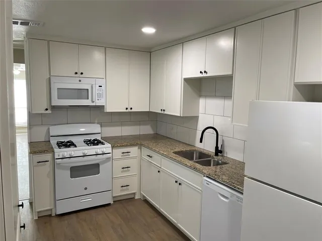 a kitchen with white cabinets stainless steel appliances and sink