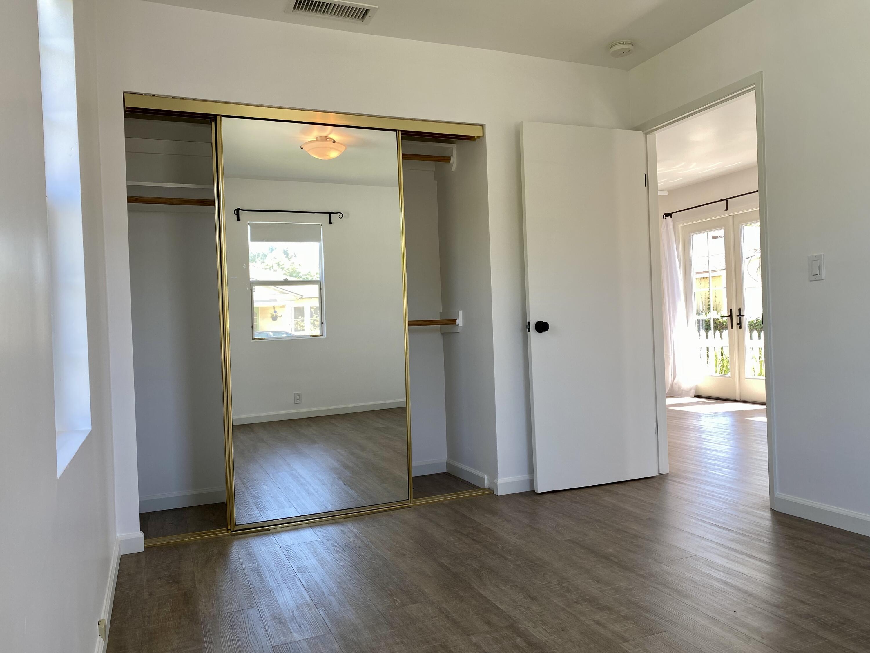 4854 8th Street Carpinteria, CA 93013 - Photo 3 of 22 an empty room with wooden floor and windows