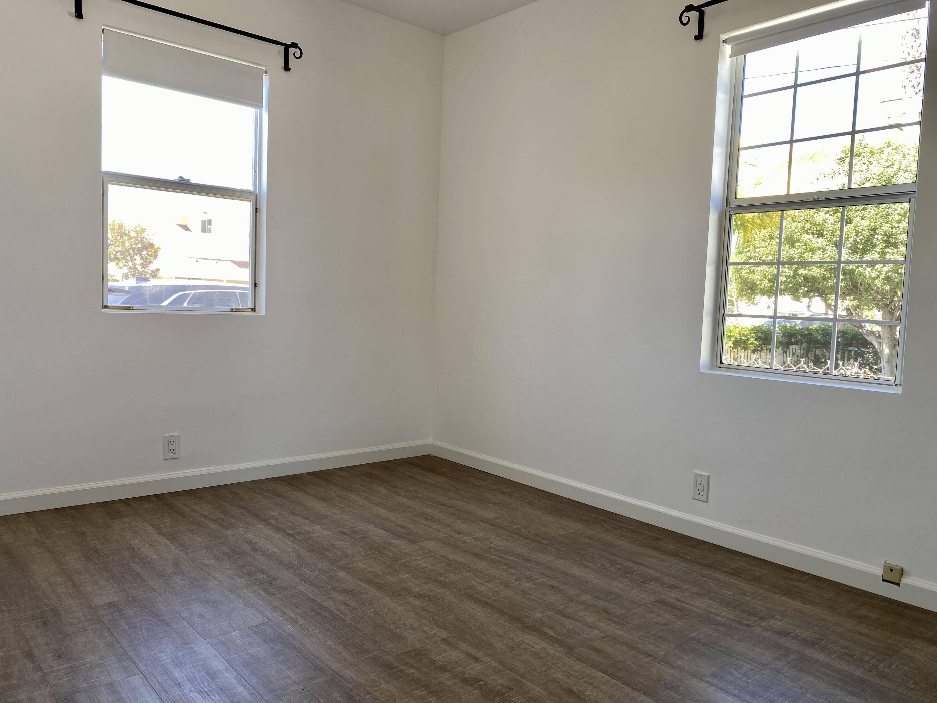 4854 8th Street Carpinteria, CA 93013 - Photo 4 of 22 an empty room with wooden floor and windows