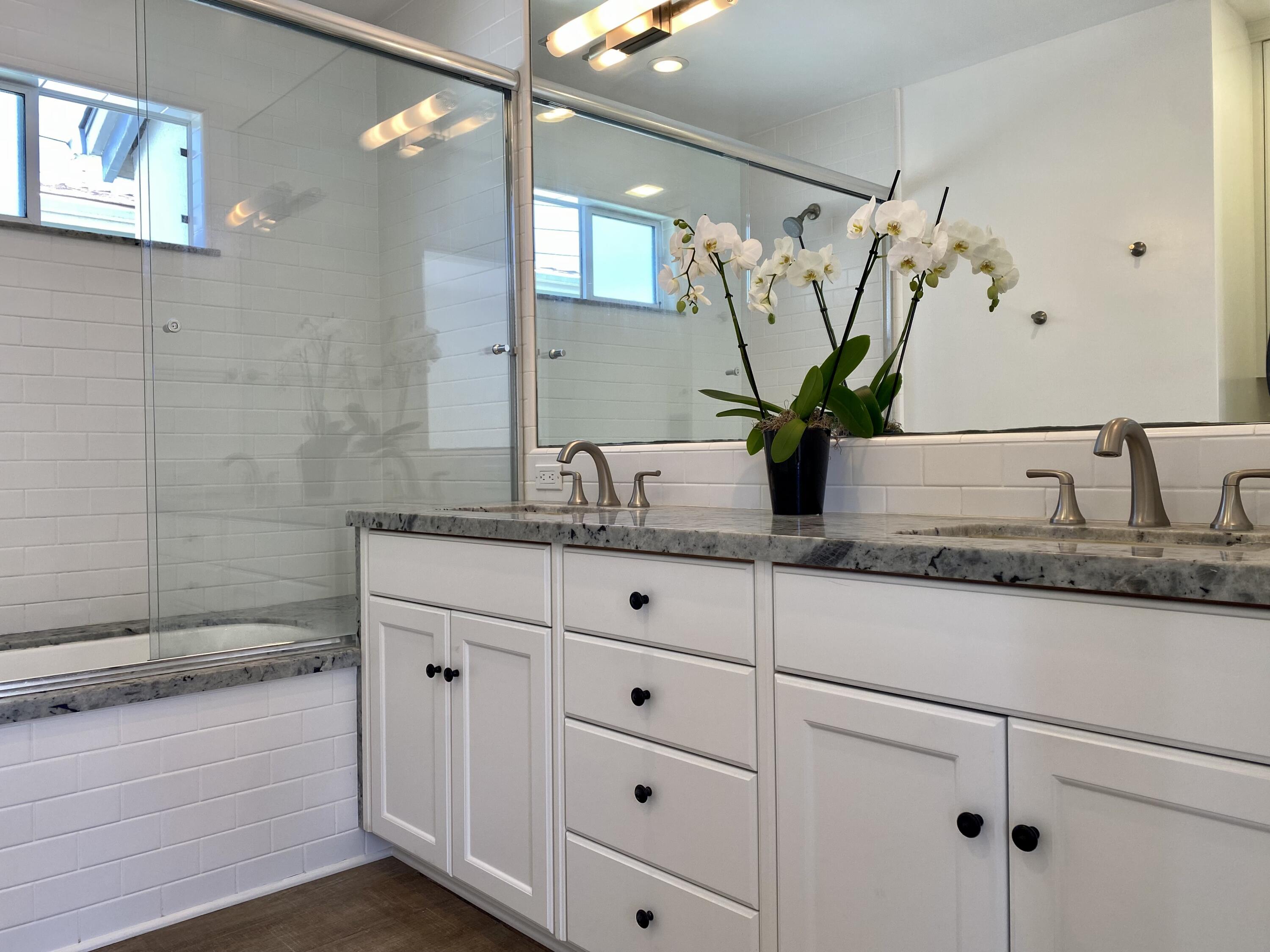 4854 8th Street Carpinteria, CA 93013 - Photo 5 of 22 a bathroom with a granite countertop sink a mirror and a shower