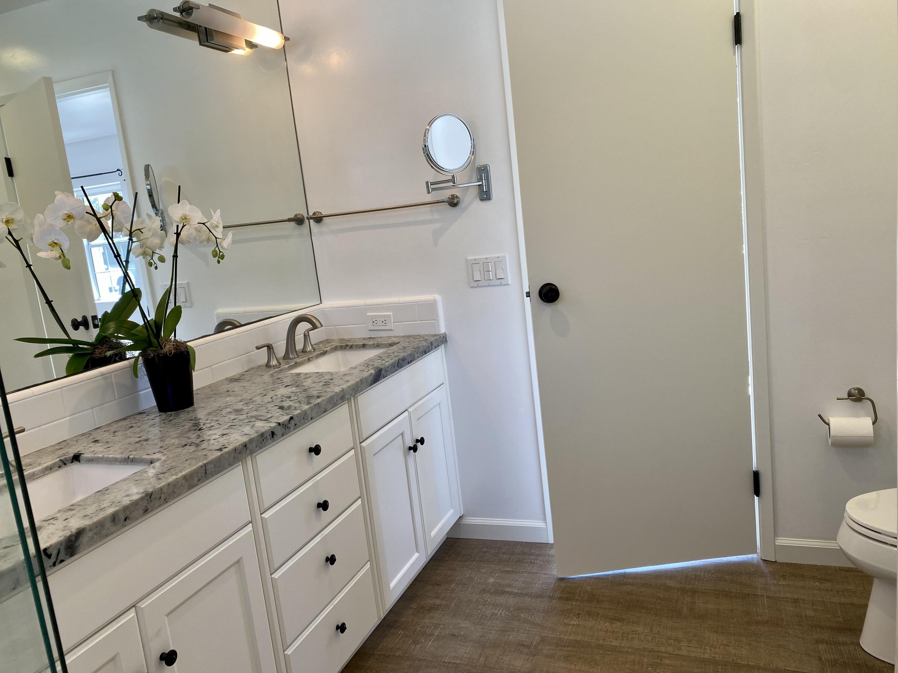 4854 8th Street Carpinteria, CA 93013 - Photo 6 of 22 a bathroom with a granite countertop sink a toilet and mirror