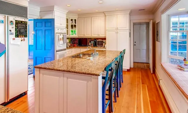 a kitchen with stainless steel appliances granite countertop a refrigerator and a stove top oven