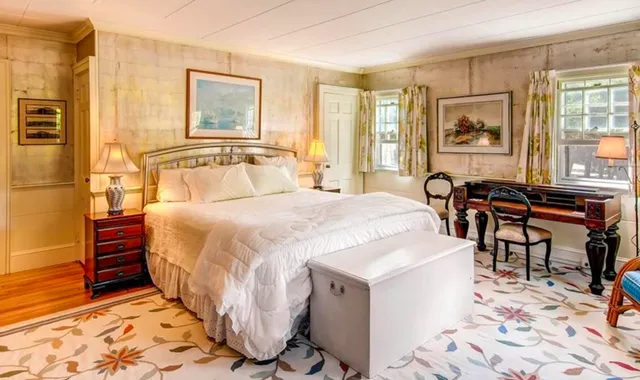 a spacious bedroom with a bed a table and chair